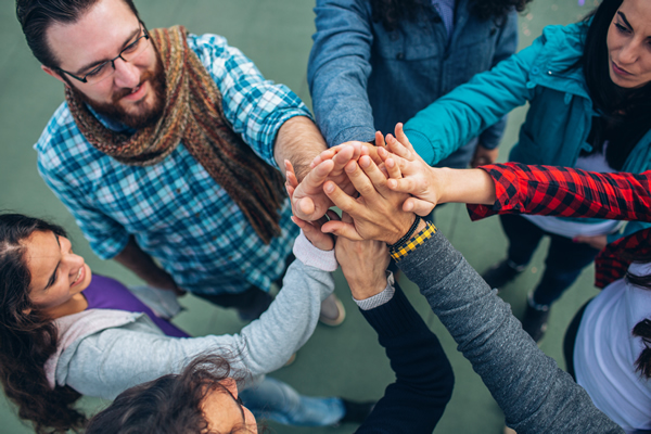 overhead view of people joining hands in a circle